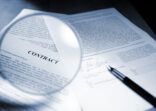 Magnifying Glass Examining Signed Legal Contract