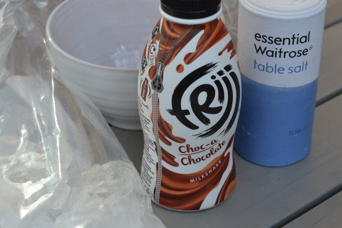 chocolate milk, ice in a bag and a container of salt