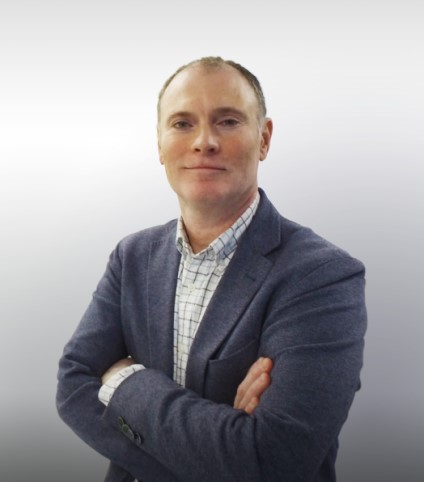 Mike Broadhurst, General Manager of Preclinical Research at Altasciences, wears a blue blazer while crossing his arms and smiling at the camera.