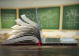 E-learning online education or internet  encyclopedia concept. Open laptop and book compilation in a classroom.