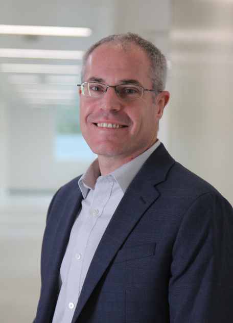 Francis Douville, Vice President of Technical Operations for Altasciences, smiles at the camera wearing a blue blazer, standing in a hallway.